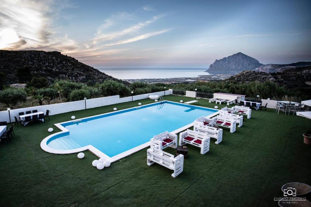 una piscina con sillas y un montón de plantas en Villa Marina, en Valderice