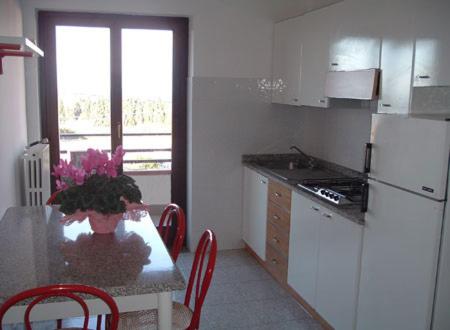 y cocina con mesa, sillas y nevera. en Residence Oasi, en Briatico