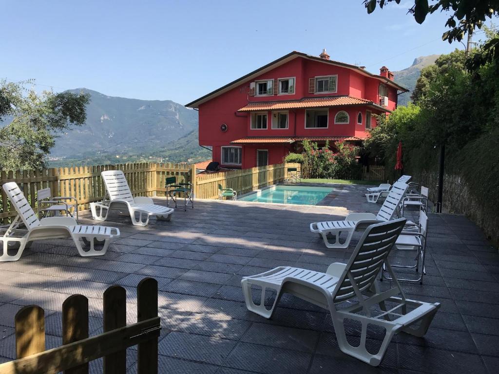 a group of lounge chairs next to a swimming pool at B&B La Casa di Alice in Camaiore