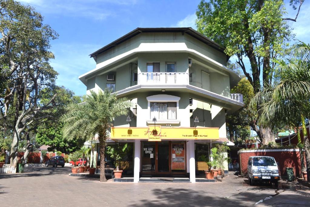 un edificio blanco y amarillo en una calle en Jaffer Bhai's Brickland Hotel, en Panchgani