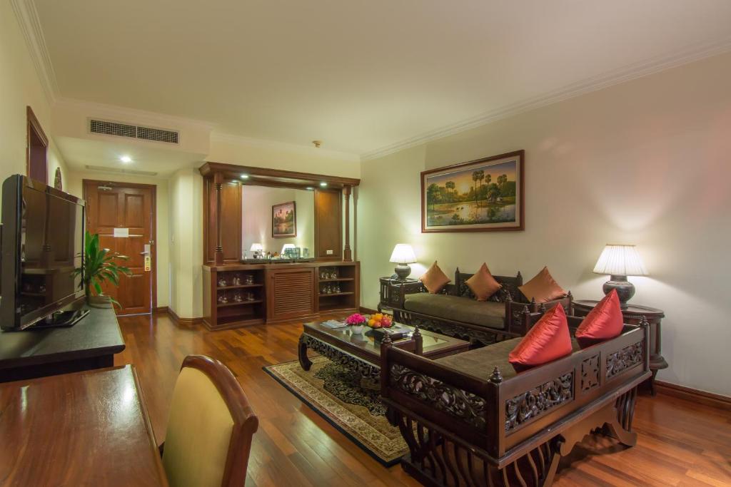 a living room with a couch and a tv at Palace Residence & Villa Siem Reap in Siem Reap