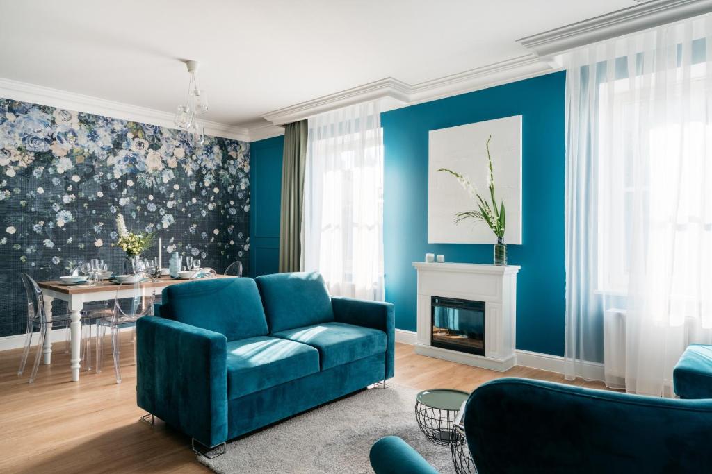 ein Wohnzimmer mit einem blauen Sofa und einem Tisch in der Unterkunft District17 - LoftAffair Collection in Krakau