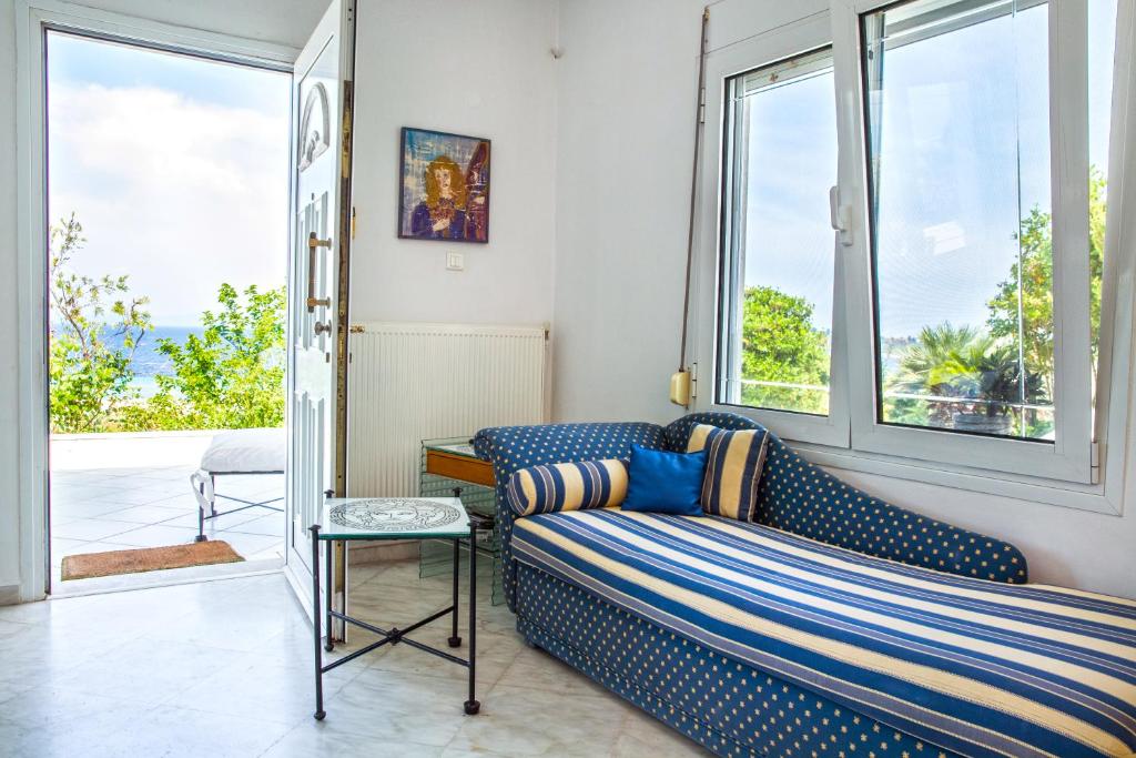a living room with a couch and large windows at Seaview dreams in Ormos Panagias