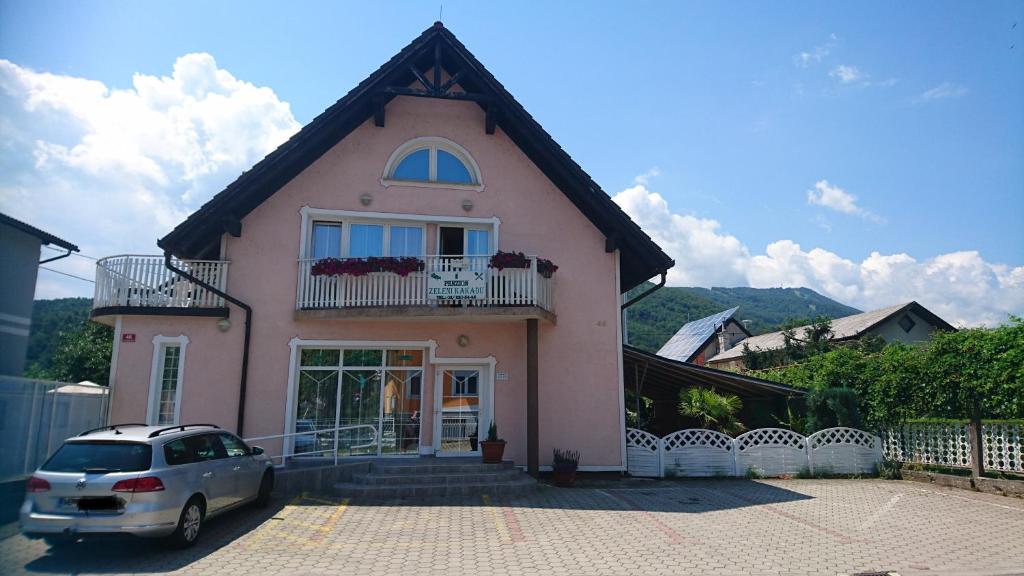 a pink house with a car parked in front of it at Penzion Zeleni Kakadu in Maribor