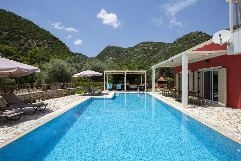 a swimming pool with mountains in the background at Villa Niriides in Lefkada Town