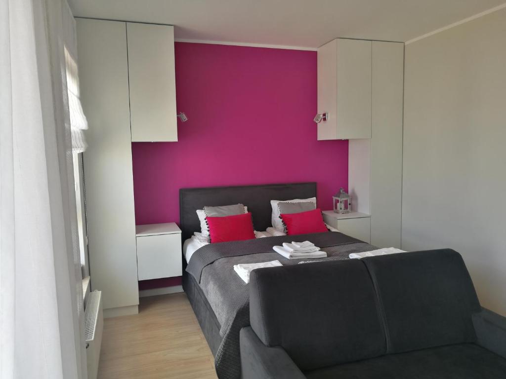 グダニスクにあるStudio Słoneczneの紫の壁のベッドルーム1室、ソファベッド1台が備わります。