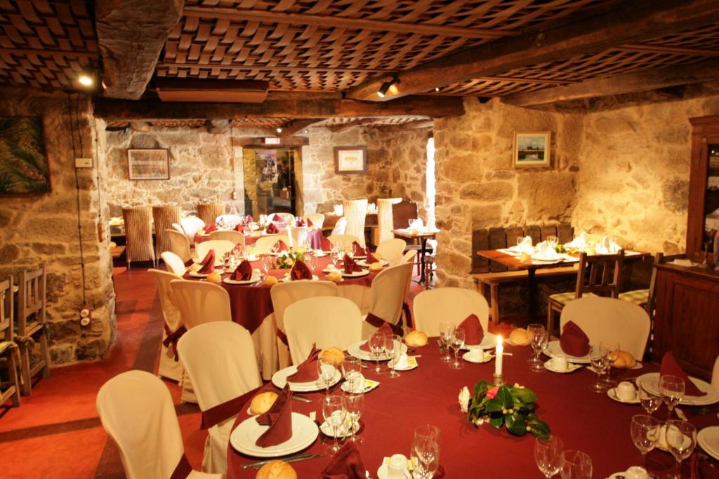 een eetkamer met een tafel en witte stoelen bij Casa Grande de Rosende in Sober