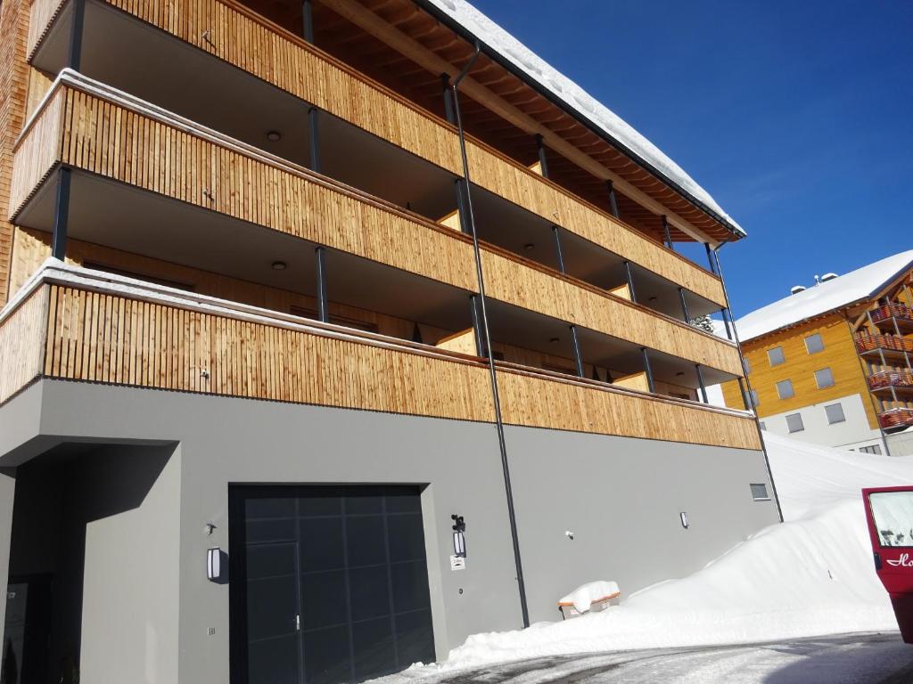 a building with a parking garage in the snow at Ferienwohnung Oberdamüls in Damuls