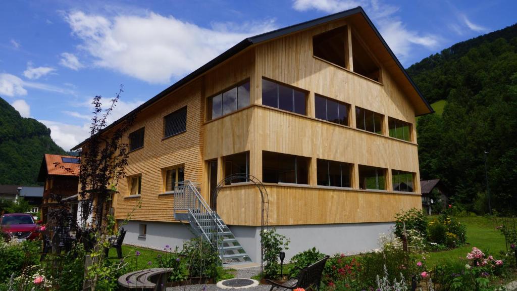 a large wooden building with a staircase in a yard at Haus Edeltraud in Mellau