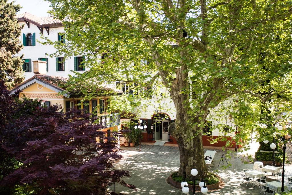 a large tree in front of a house at Residenza d'Epoca Albergo Quattro Fontane in Venice-Lido
