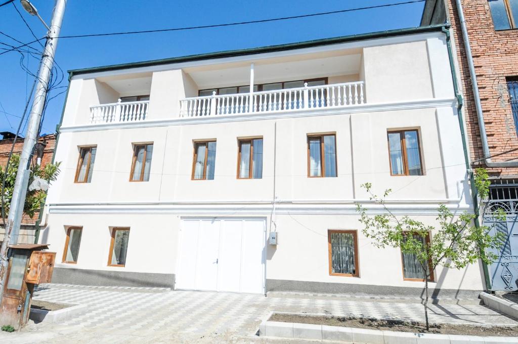 Una casa blanca con un balcón encima. en вилла, en Tiflis
