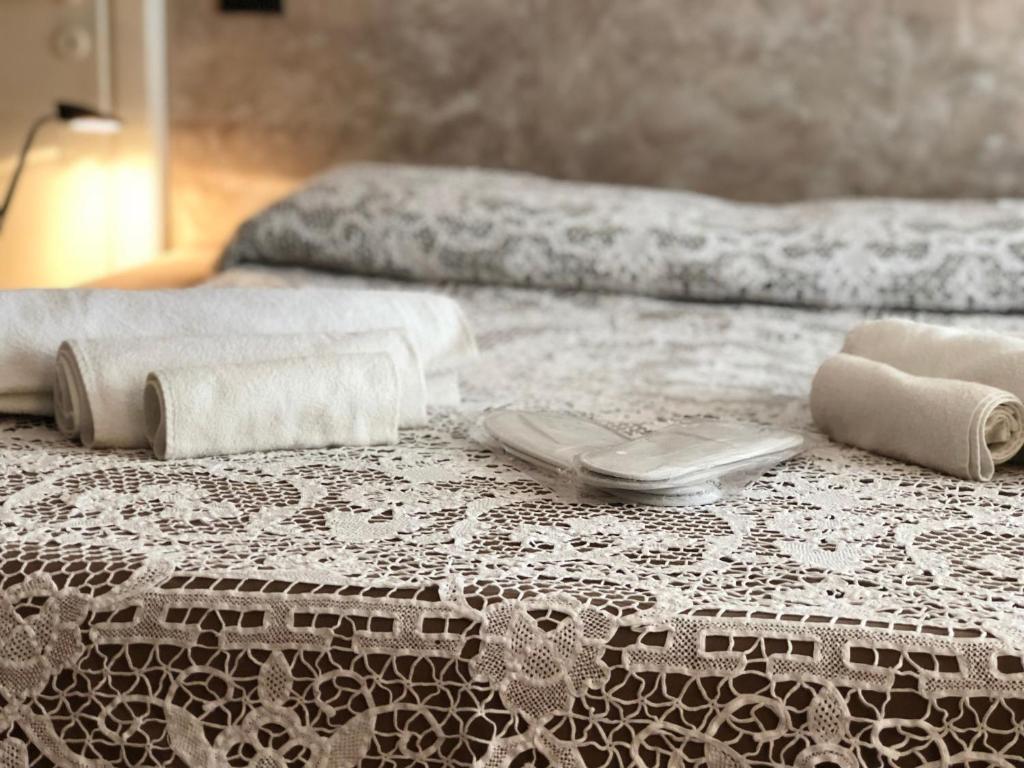 Una cama blanca con toallas y toallas. en Open Space Verona en Verona