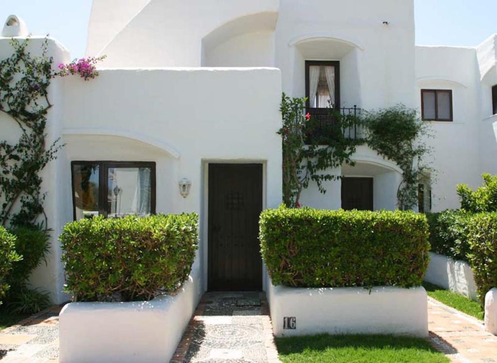 een wit huis met een deur en wat struiken bij Villacana 2816 in Estepona