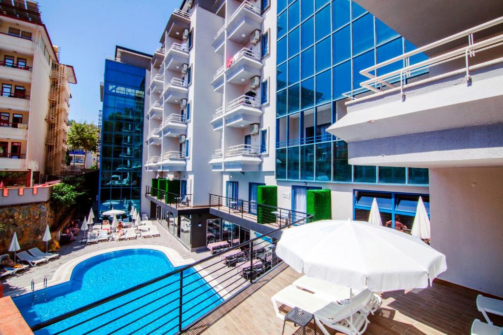 a hotel with a swimming pool and an umbrella at Ramira City Hotel - Adult Only (16+) in Alanya