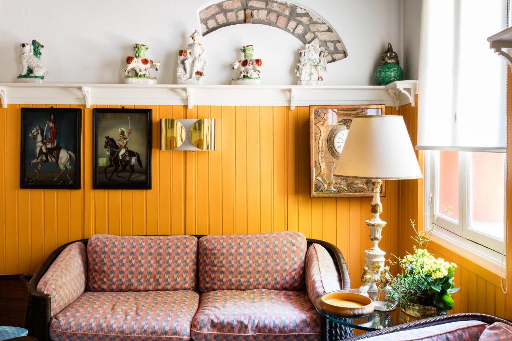 a living room with a couch and pictures on the wall at Residenza d'Epoca Albergo Quattro Fontane in Venice-Lido