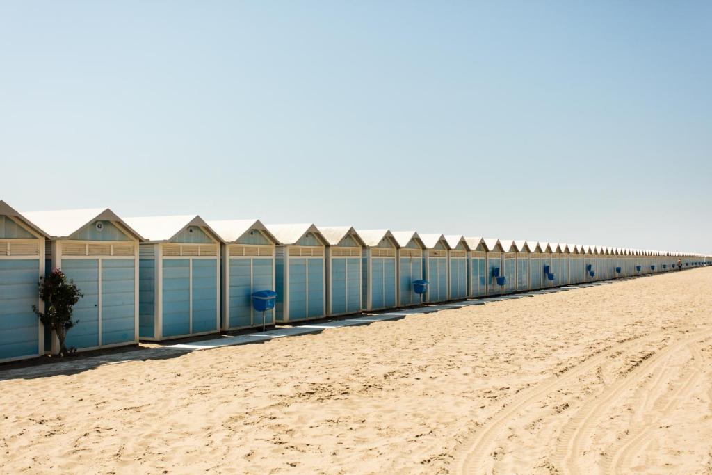 a row of beach huts on a sandy beach at Residenza d'Epoca Albergo Quattro Fontane in Venice-Lido