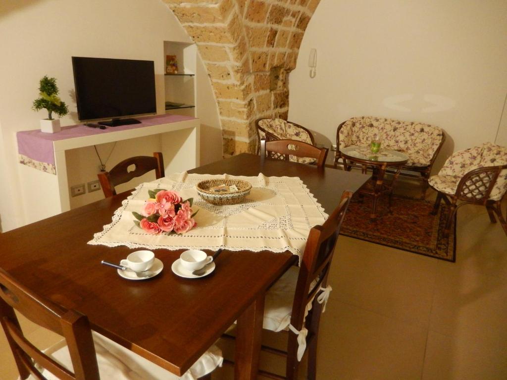 een eetkamer met een houten tafel en stoelen bij Sweet Home Arco Porta Luce in Galatina