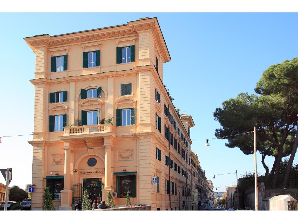 een hoog geel gebouw op de hoek van een straat bij Appartamento d'epoca Colosseo Art Gallery in Rome