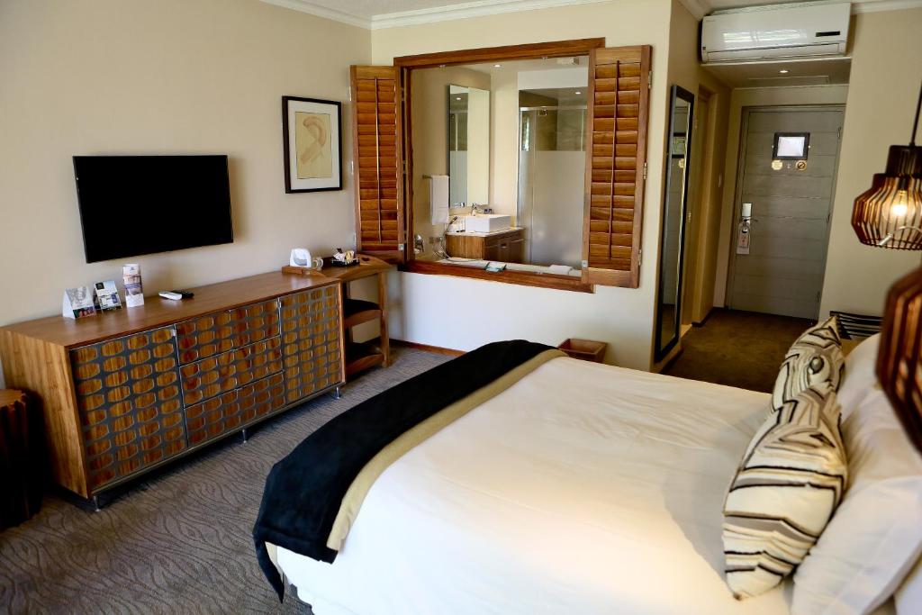 Habitación de hotel con cama y TV en Windhoek Country Club Resort en Windhoek