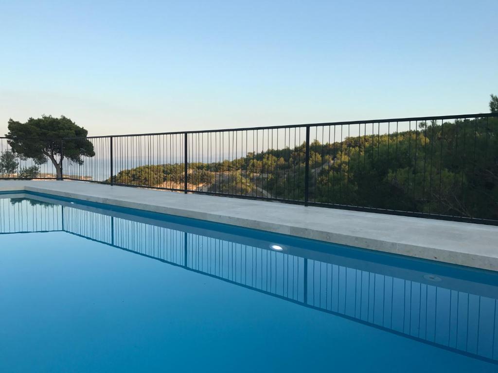 una piscina de agua azul y una valla en Villa Pietra, en Selca