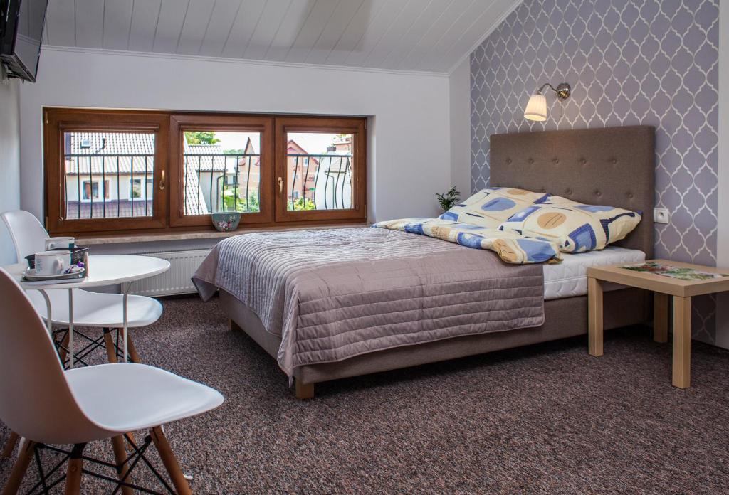 ブワディスワボボにあるAnioł Morskiのベッドルーム1室(ベッド1台、テーブル、椅子付)