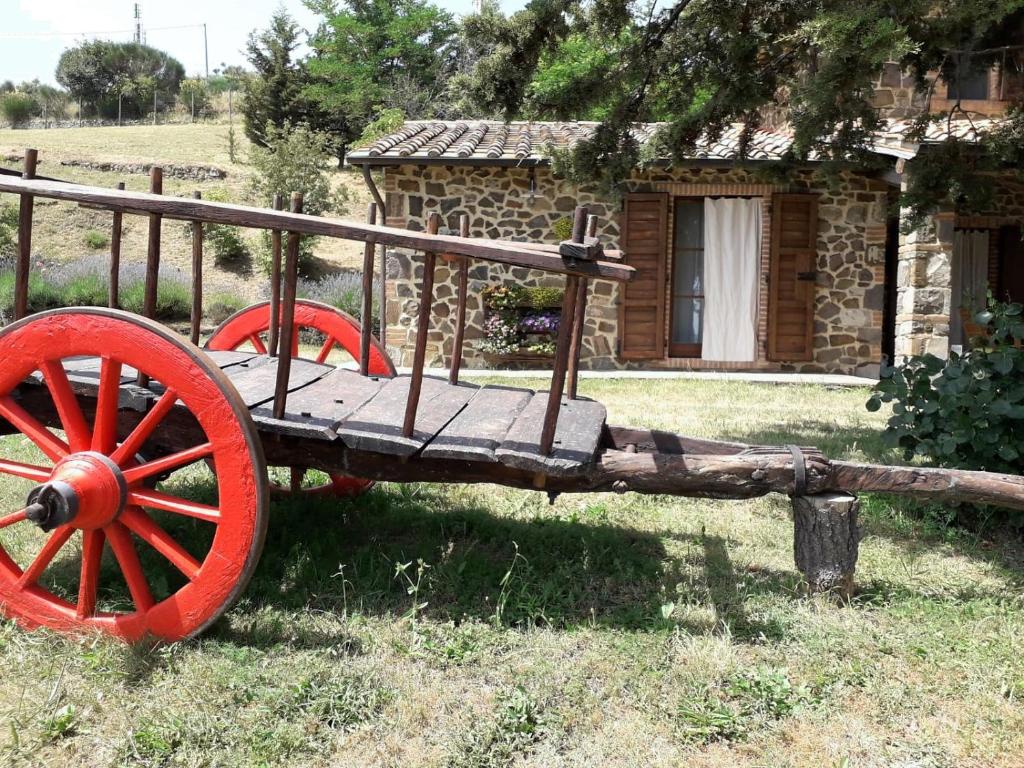 a wooden cart with red wheels in front of a building at Agriturismo "Apparitoio" in Montelaterone