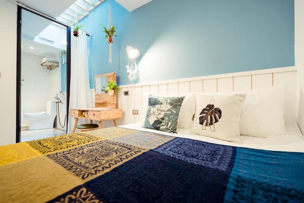 a bedroom with a bed with a blue wall at A.R.T. in Kaohsiung