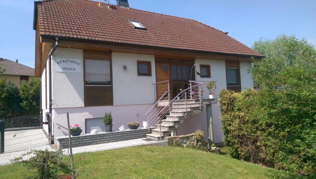 mały biały dom ze schodami na dziedzińcu w obiekcie Apartment Weber w mieście Offenheim
