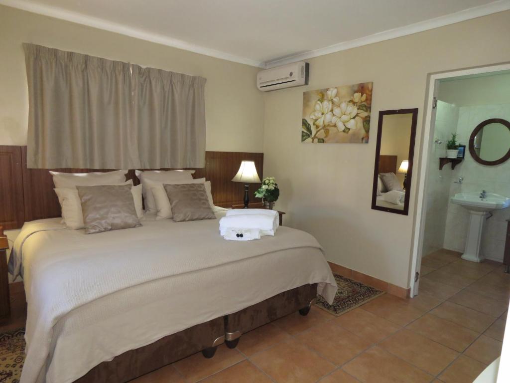 a bedroom with a large bed and a sink at Butterscotch B&B in Pinetown