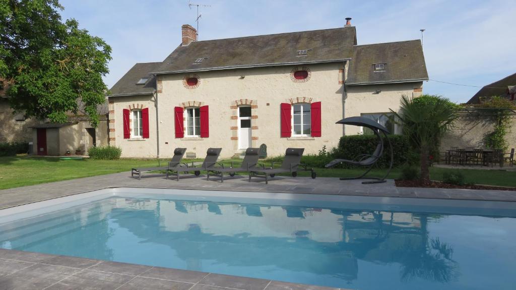 a house with a swimming pool in front of a house at Gîte Les Mirabelles in Saint-Léonard-en-Beauce