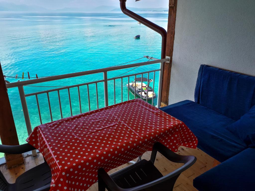 a balcony with a table and an umbrella and the ocean at Villa Bube in Trpejca