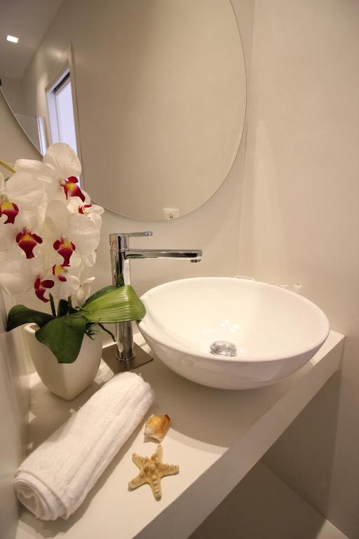 a bathroom with a sink and a vase with flowers at Il Borghetto Resort & Spa in Tropea