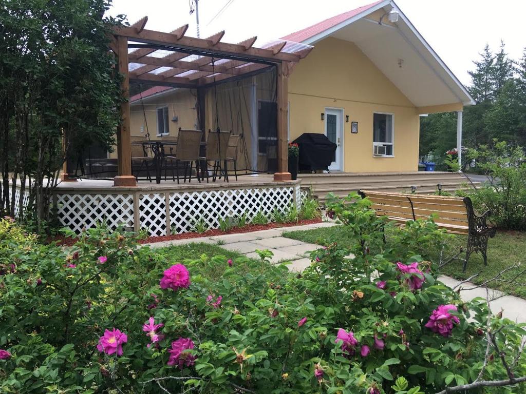 a house with a deck with a bench and flowers at Paradis du Lac Nairne in Notre-Dame-des-Monts