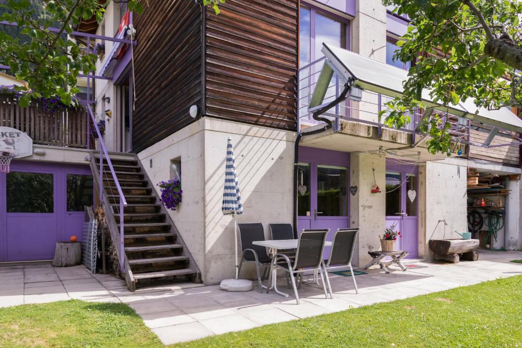 a house with purple doors and a table and chairs at B&B Gottardo in Airolo