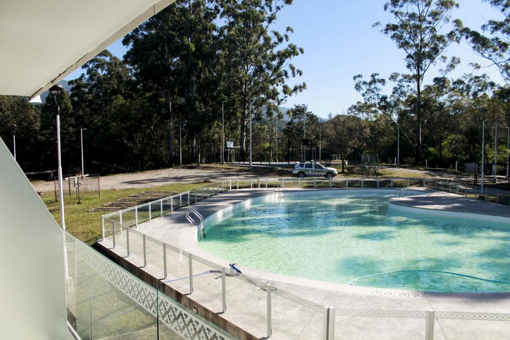 una piscina in un parco con un'auto sullo sfondo di Hostería Atahualpa Yupanqui a Tafí Viejo