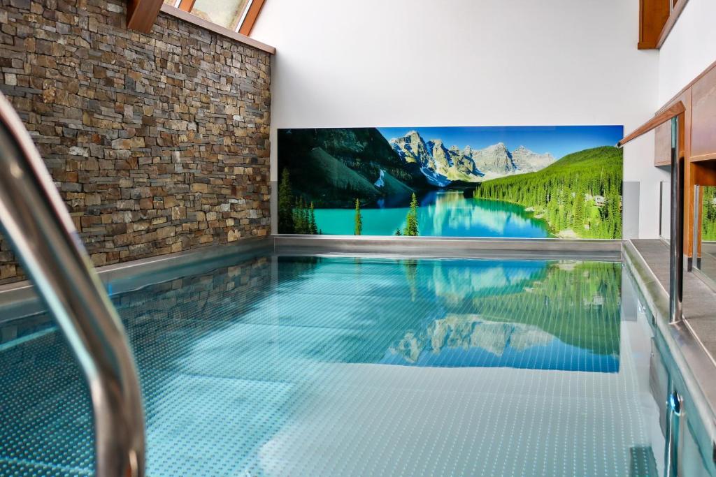 a swimming pool in a house with a tv on the wall at Hotel Bystra in Białka Tatrzańska
