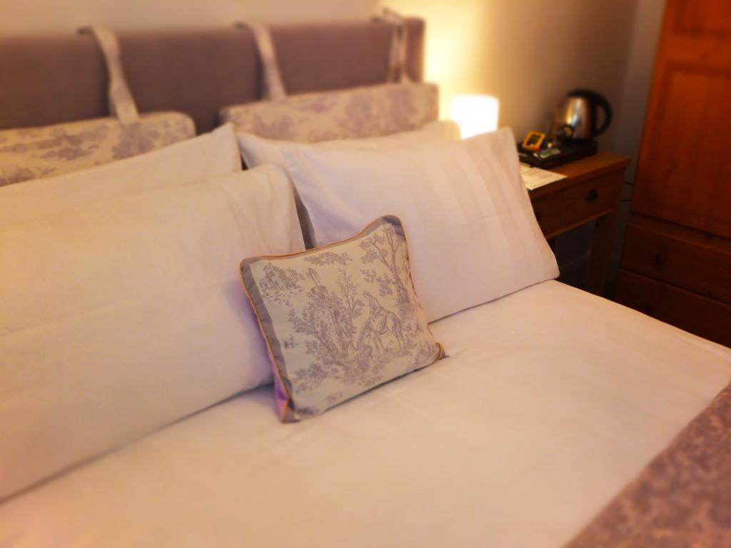 a white bed with a pillow sitting on it at Bradley's Bed & Breakfast in Strabane
