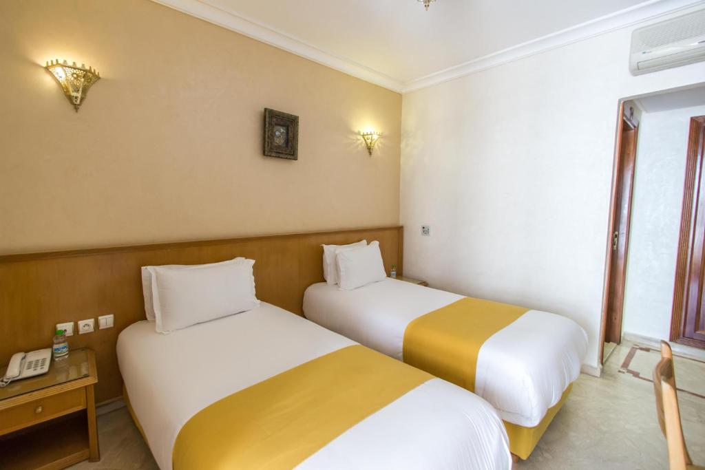 a hotel room with two beds and a window at Zahrat Al Jabal in Fès