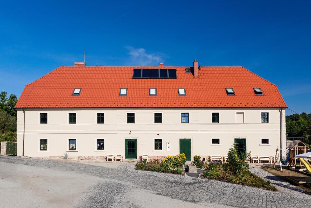 duży biały budynek z pomarańczowym dachem w obiekcie Gościniec Pod Gruszą w mieście Świerzawa