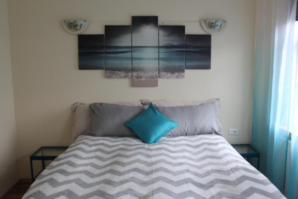 a bedroom with a bed with two blue pillows at House overlooking the bay in Borgarnesi in Borgarnes