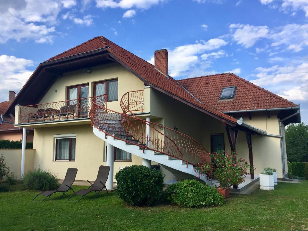 una casa con due ponti e due sedie nel cortile di Mária Apartmanház a Zalakaros