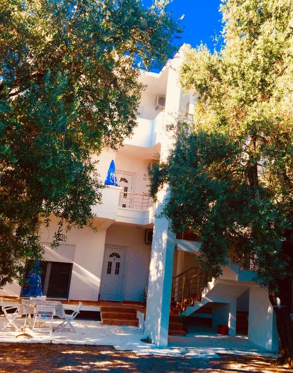 ein weißes Gebäude mit Bäumen davor in der Unterkunft Montebello Inn apartments in Ulcinj