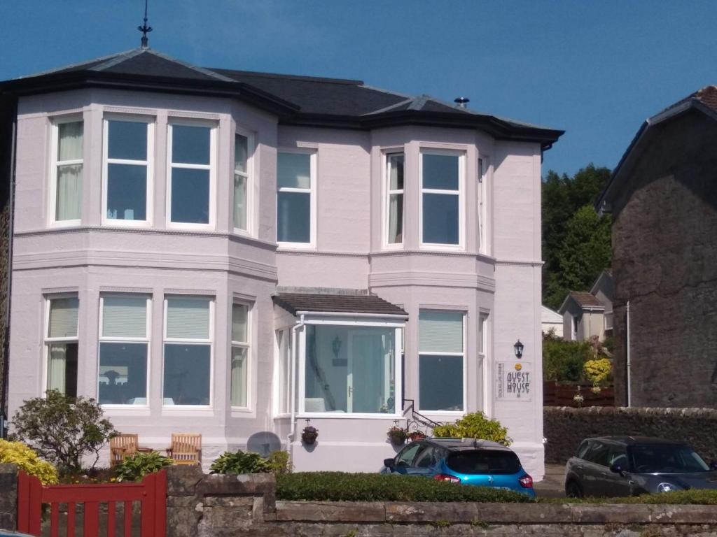 a white house with a black roof at Douglas Park Guest House in Dunoon