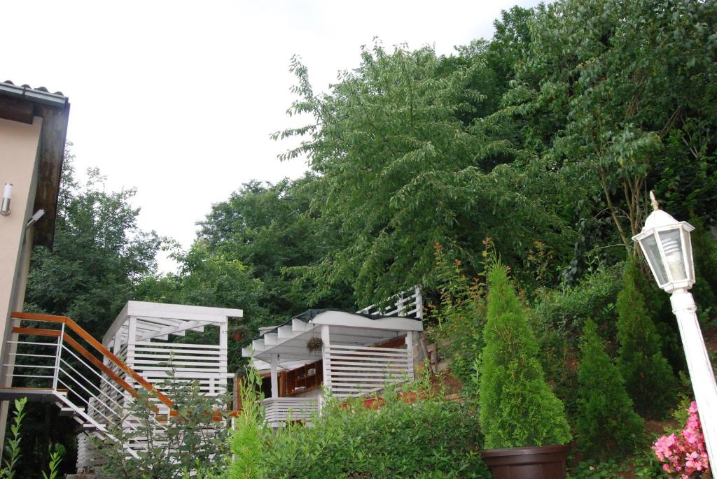 a couple of white modular homes in a garden at Exclusiv Apartmani PERGOLO Centar in Soko Banja
