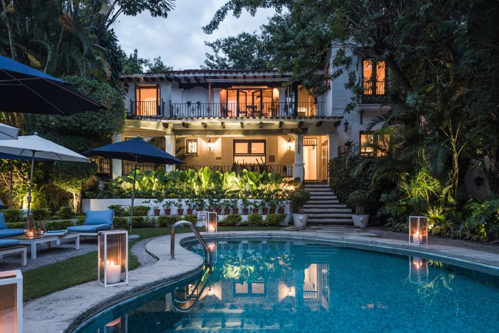 a house with a swimming pool in front of a house at Las Casas B&B Boutique Hotel, Spa & Restaurante Cuernavaca in Cuernavaca