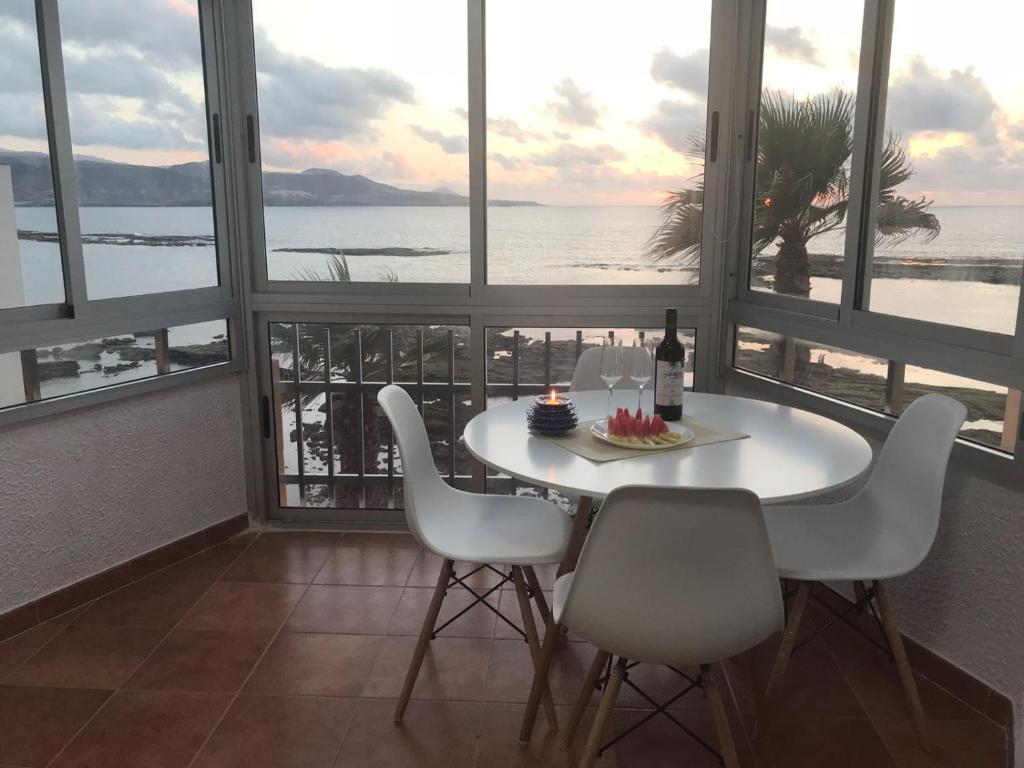 a table and chairs in a room with a view of the ocean at Apartamentos 306 -05 vista Teide in Las Palmas de Gran Canaria