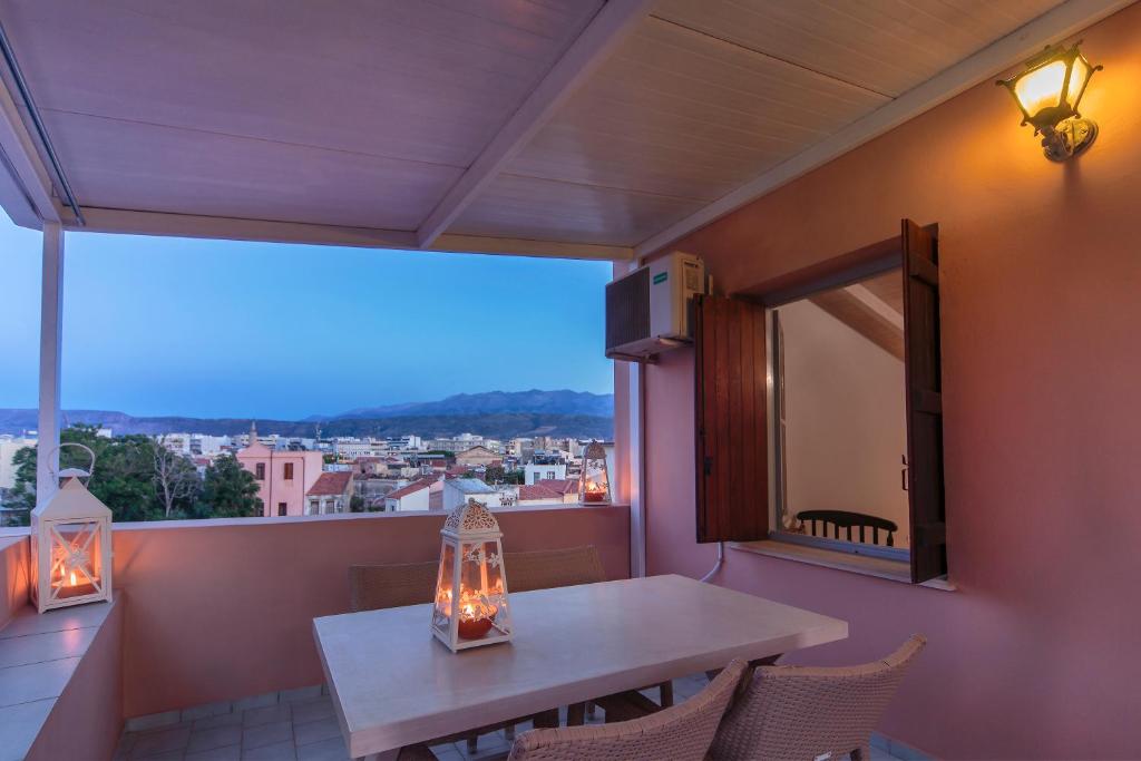 a balcony with a table and chairs and a large window at KasteliSuites in Chania