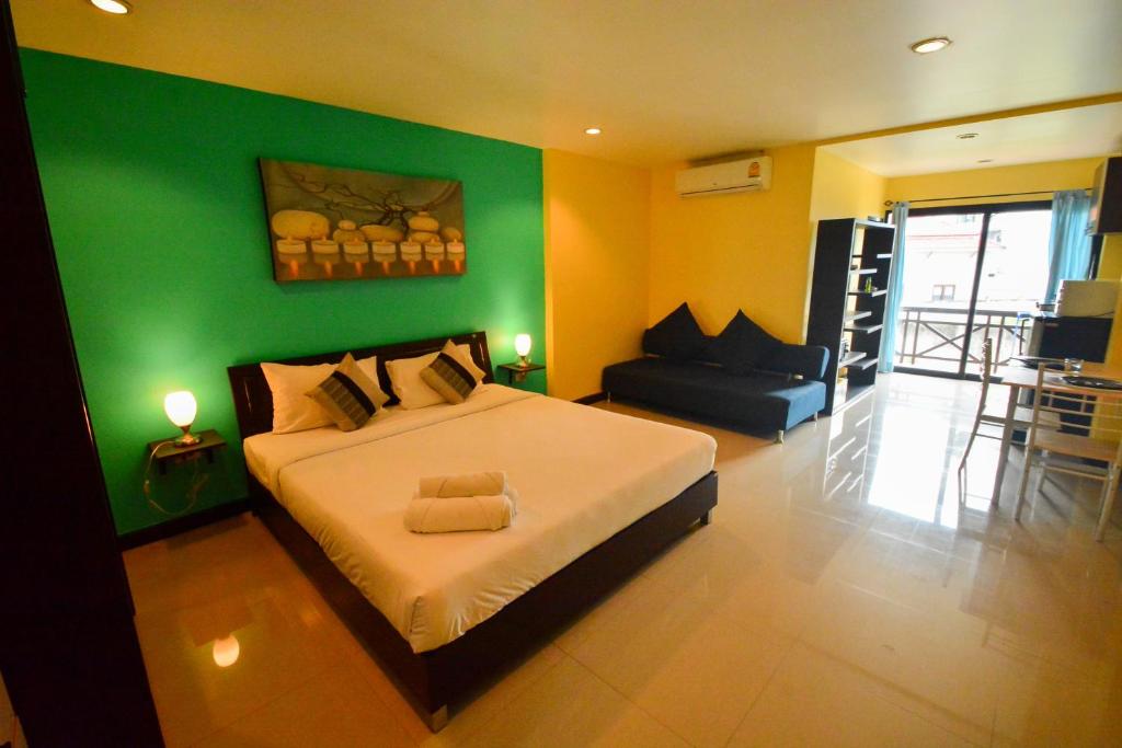 Gecko Hotel في بوفوت: غرفة نوم بسرير كبير وجدار أخضر