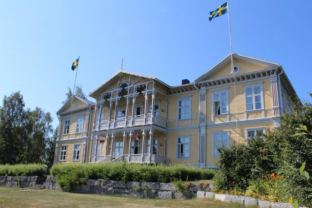 una casa grande con dos banderas encima en Filipsborg, the Arctic Mansion en Kalix