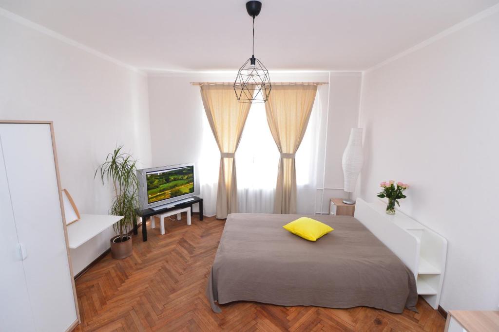 um quarto com uma cama com uma almofada amarela em Beatrises apartamenti em Riga